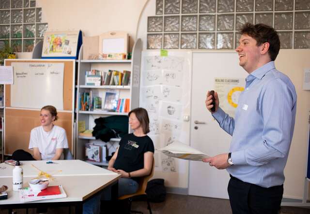 Ein Mann trägt vor Menschen vor.